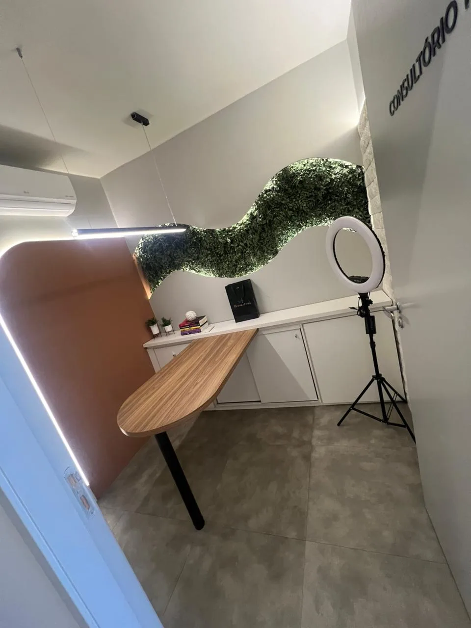 Consultório de avaliação com bancada orgânica e parede verde
