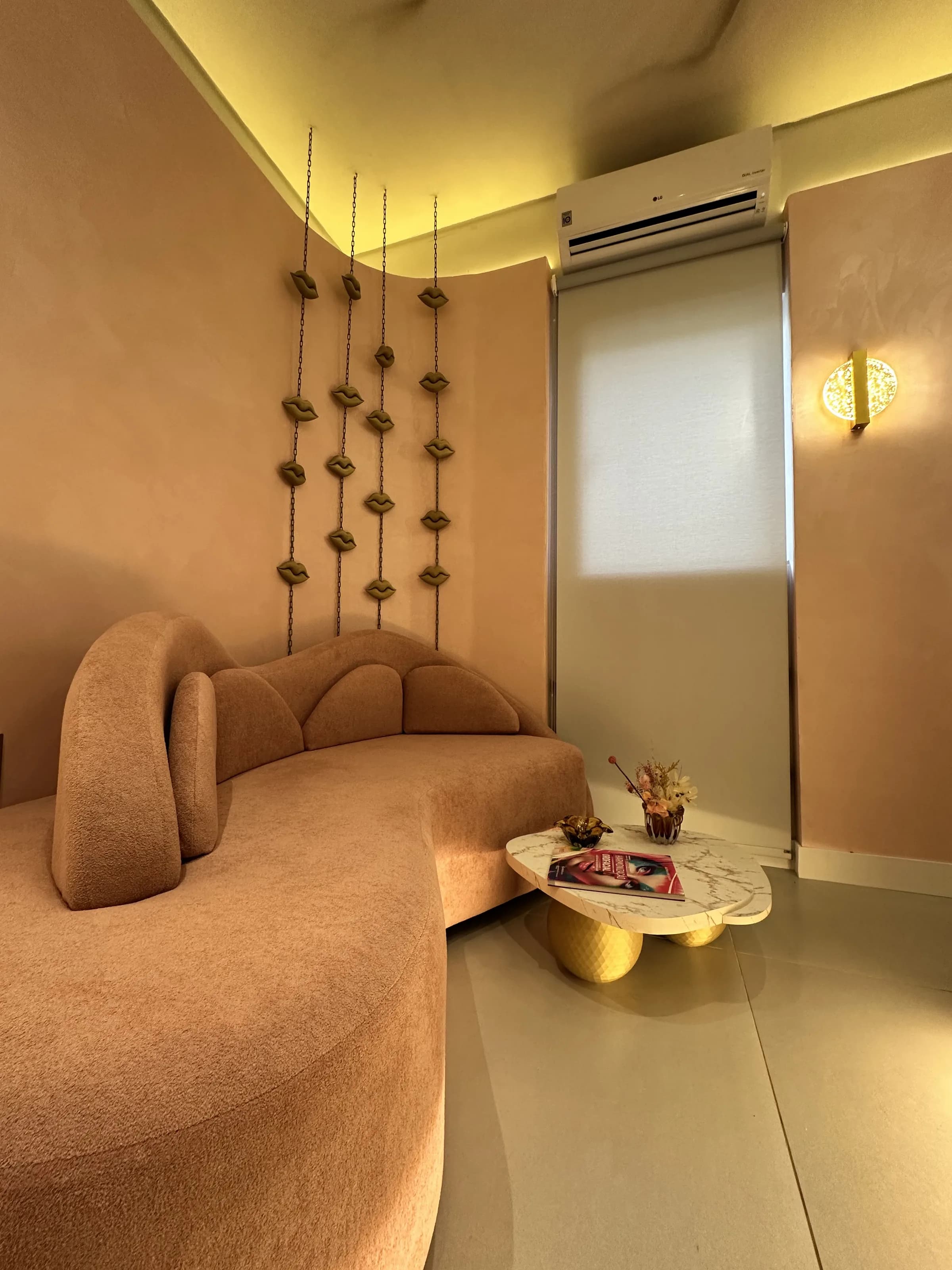 Sala de descanso pós-procedimento — sofá curvo e painel decorativo