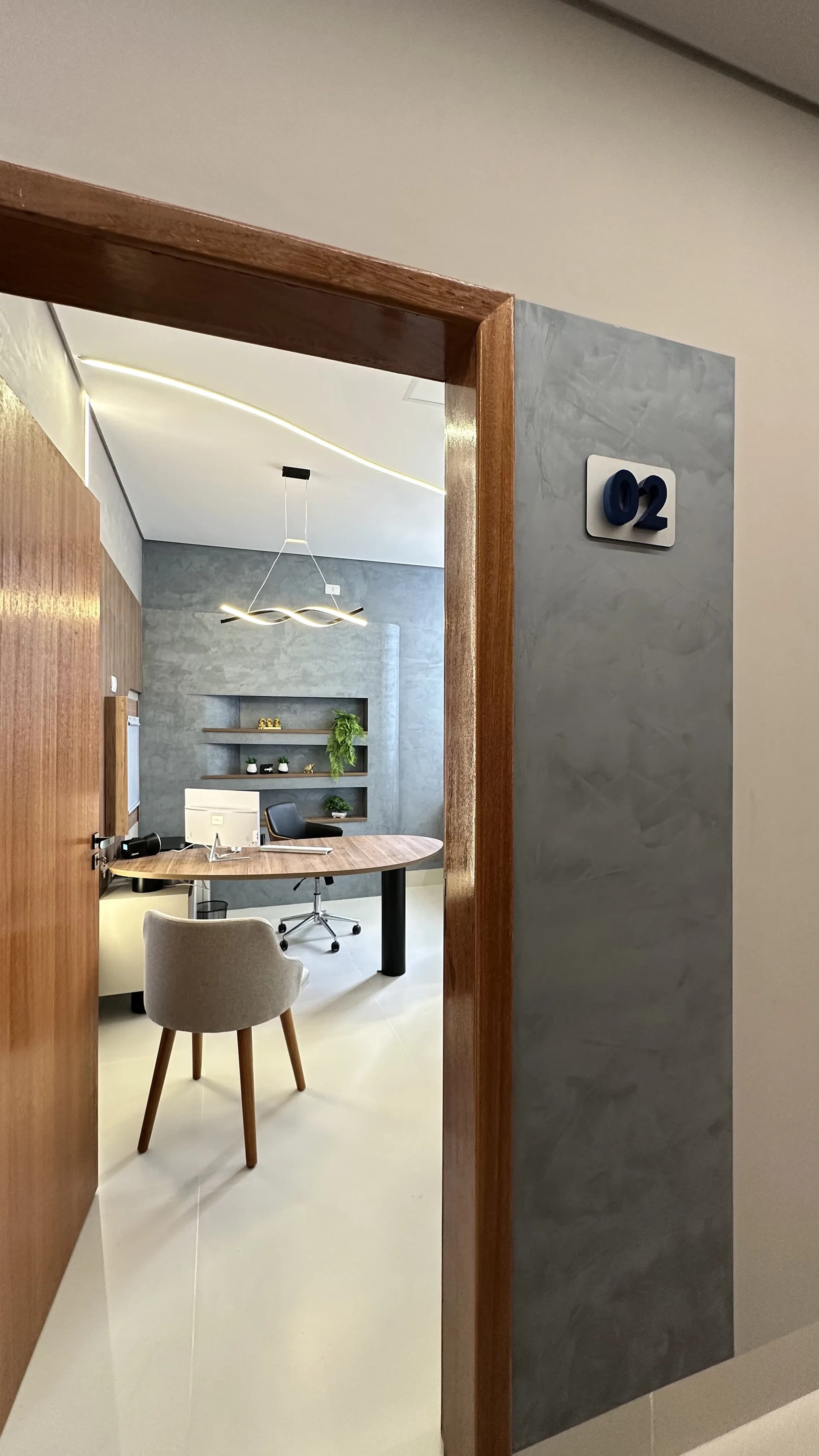 Acesso ao consultório 02 da Clínica Salus — paleta concreto e madeira