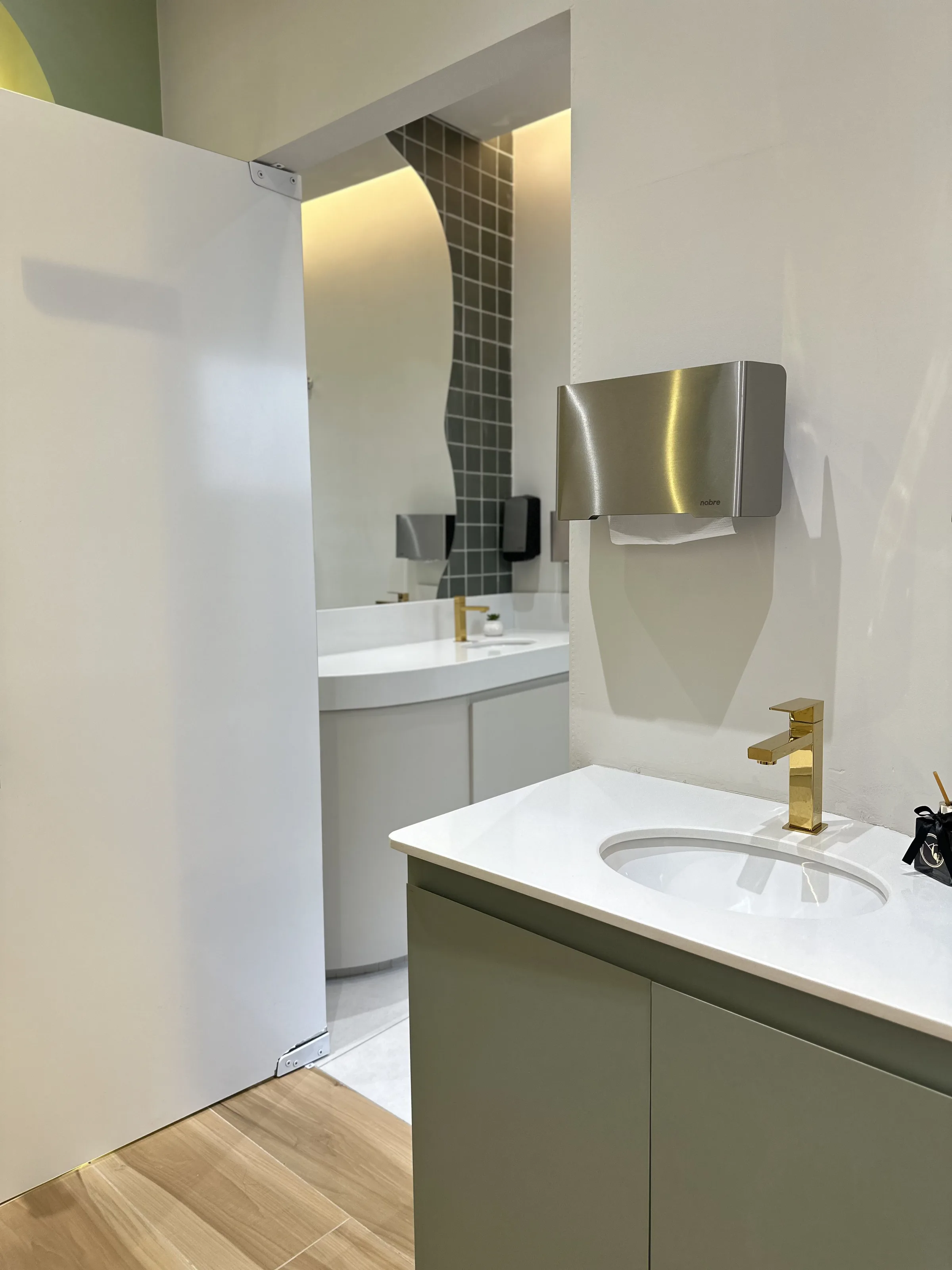 Consultório com bancada em vidro fosco e espelho arqueado