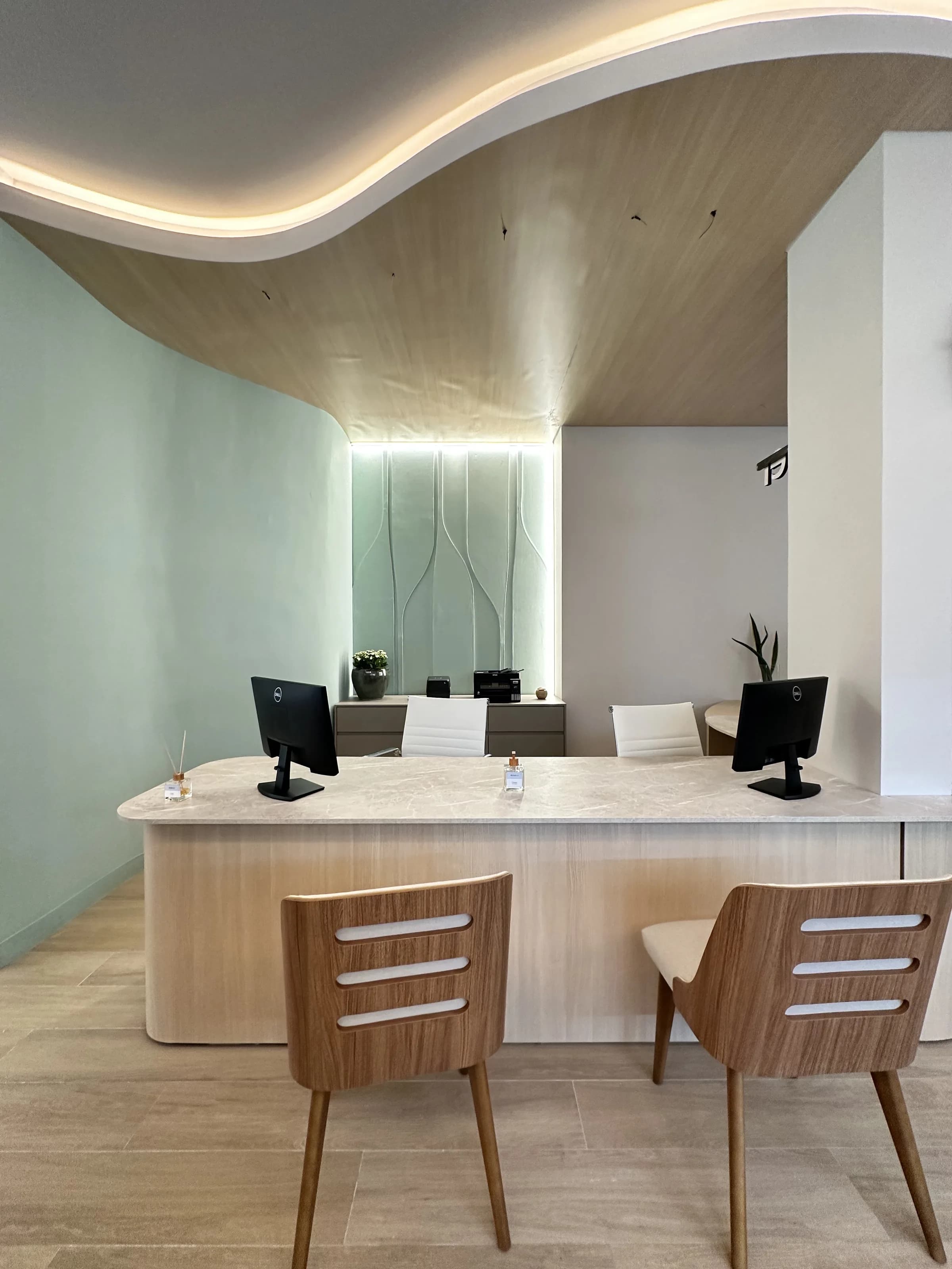 Sala de espera com sofá curvo e janelas altas