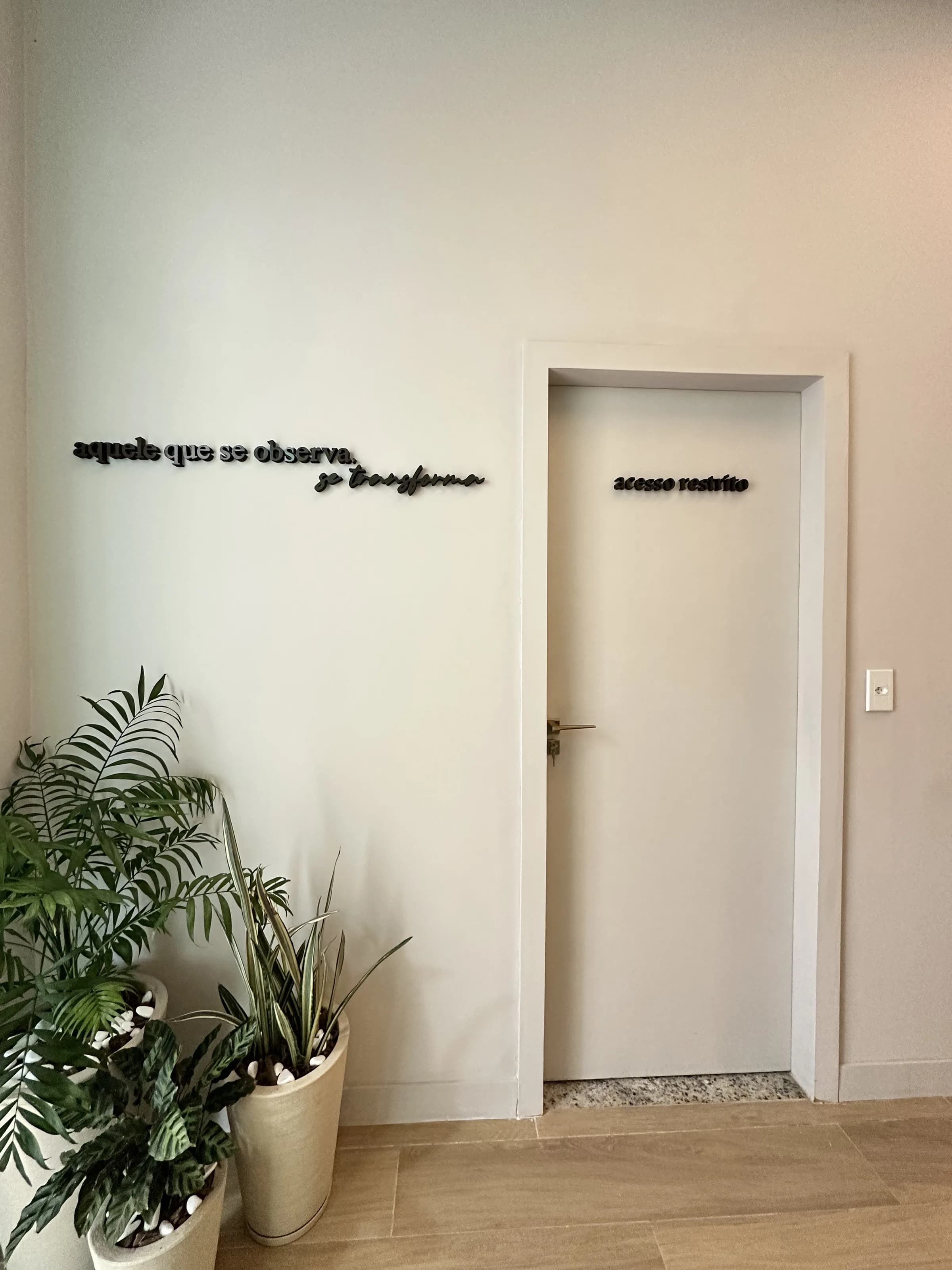 Hall de chegada do Laboratório Biocenter — frase aplicada e plantas reais